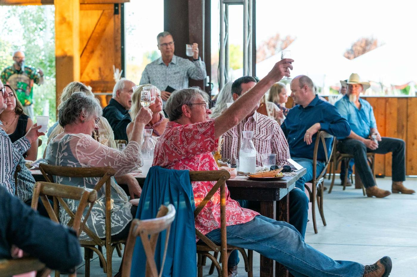 Crowd of people raising glasses for a toast