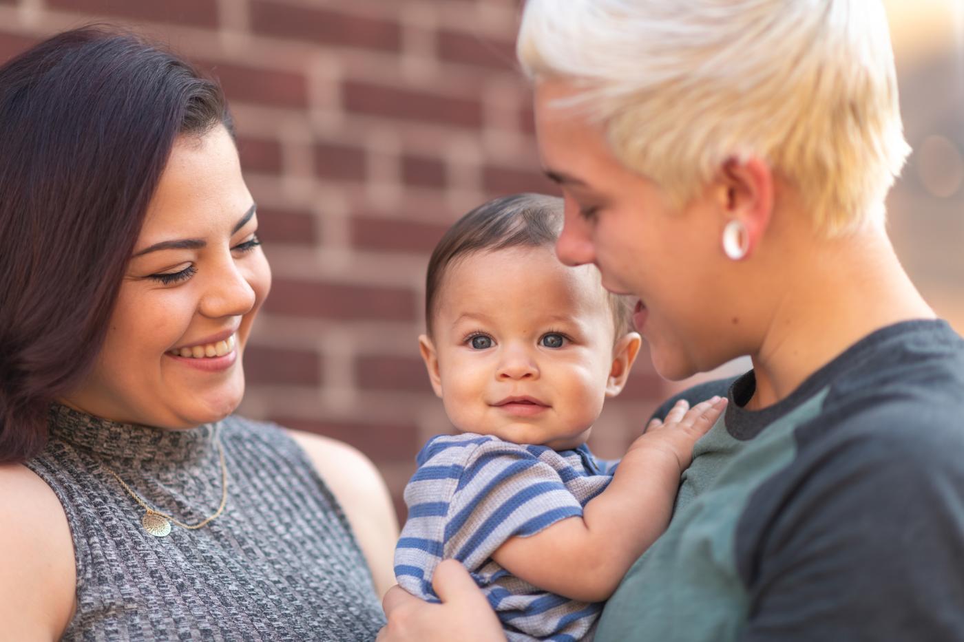 Two women holding a baby
